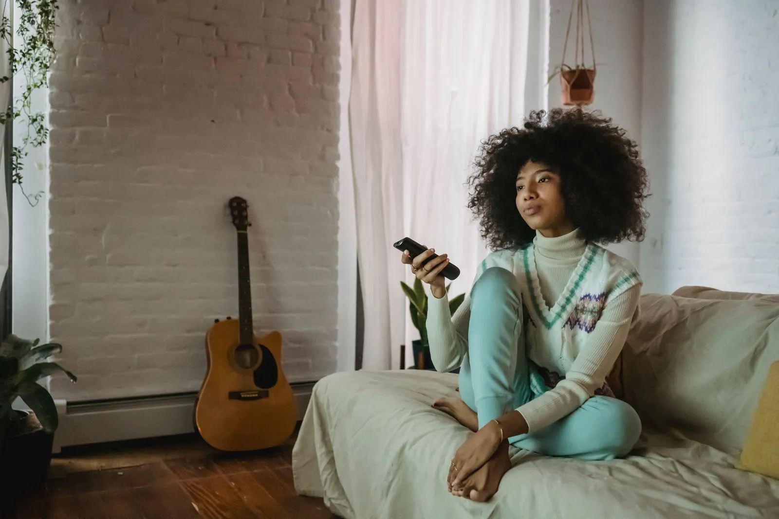 Person relaxing on a sofa watching TV at home